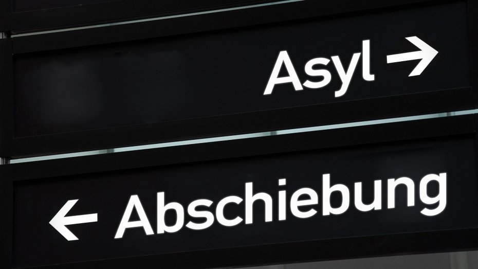 Schild mit der Aufschrift "Asyl" und einem Pfeil in eine Richtung sowie "Abschiebung" und einem Pfeil in die andere Richtung