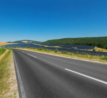 Landstraße in Rheinland-Pfalz führt an Solarfeld vorbei