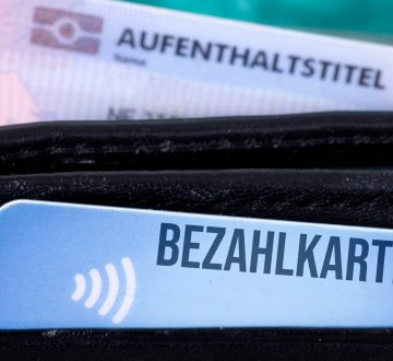 Symbolbild: Bezahlkarte und Aufenthaltstitel in einem Geldbeutel